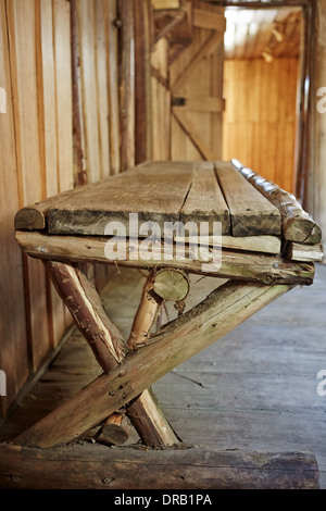 Fatto a mano panca di legno all'interno della vecchia cabina in legno Foto Stock