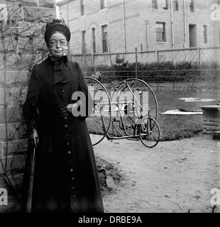 Ritratto di una donna nel periodo abito nella parte anteriore di un inizio di due-sede di triciclo. Fotografato intorno al 1900.