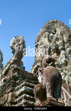 Custode di Lion, Naga la testa e la faccia di Avalokiteshvara in background al tempio Bayon, Cambogia Foto Stock