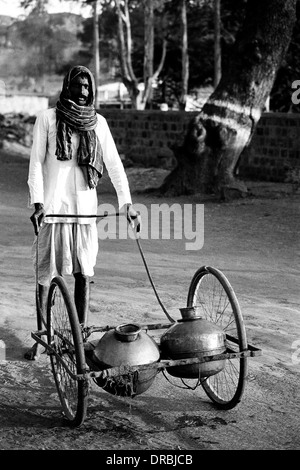 L'uomo la vendita di acqua in pentole di alluminio, Badami, Karnataka, India, 1985 Foto Stock