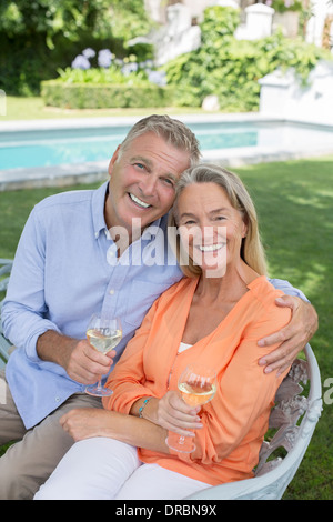 Coppia senior di bere vino in cortile Foto Stock