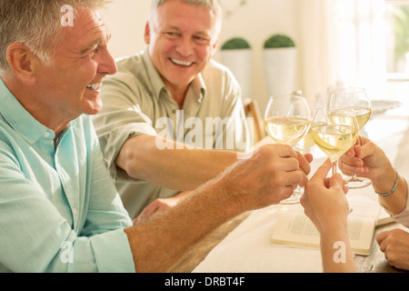 Senior amici tostatura di bicchieri di vino Foto Stock