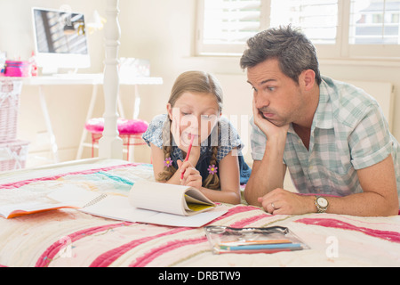 Padre aiutando la figlia con i compiti Foto Stock