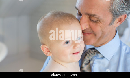 Padre sorridente holding baby Foto Stock