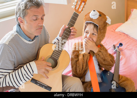 Padre e figlio a suonare la chitarra insieme Foto Stock