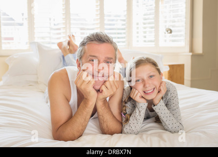 Padre e figlia la posa sul letto Foto Stock