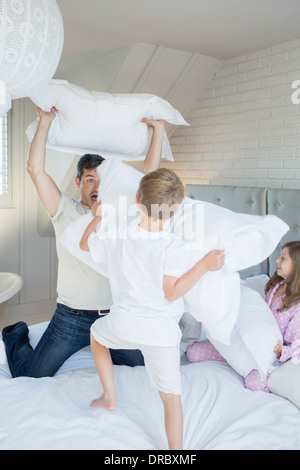 Padre e figli aventi pillow fight Foto Stock