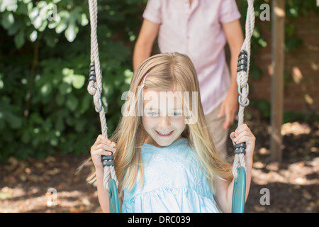 Padre figlia di spinta su swing Foto Stock