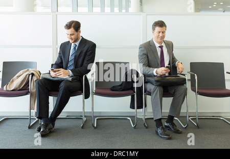 Uomini d'affari in seduta area di attesa Foto Stock