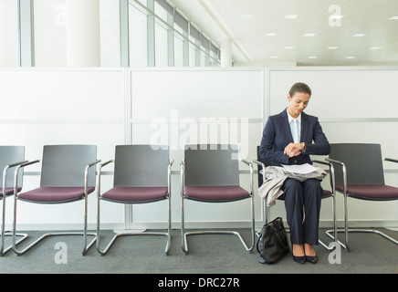 Imprenditrice controllo orologio da polso in office Foto Stock