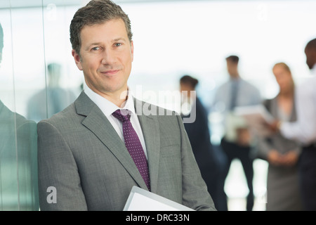 Imprenditore sorridente in ufficio Foto Stock