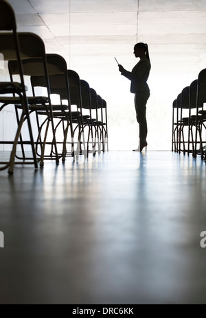 Silhouette di imprenditrice con tavoletta digitale in ufficio Foto Stock