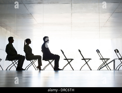 La gente di affari seduti in sedie da ufficio in una riga Foto Stock