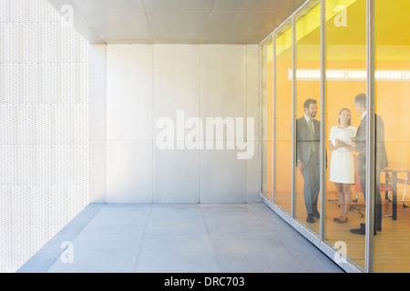 La gente di affari parlando a finestra di ufficio Foto Stock