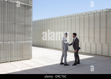 Uomini d'affari si stringono la mano all'aperto Foto Stock
