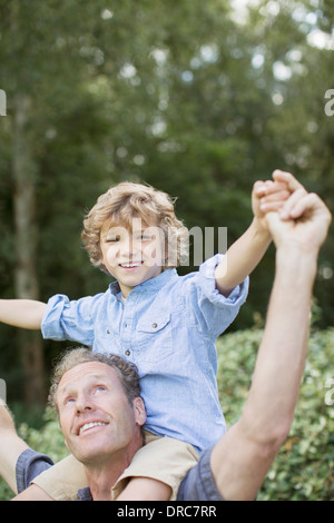 Padre figlio che porta sulle spalle all'aperto Foto Stock
