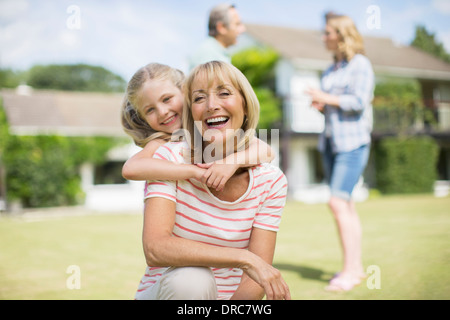 Nonna e nipote abbracciando all'aperto Foto Stock