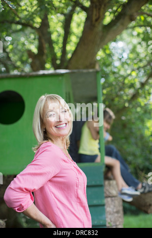 Donna sorridente con treehouse in background Foto Stock