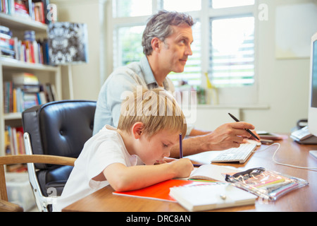 Padre e figlio che lavorano in ufficio in casa Foto Stock