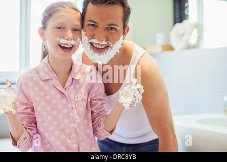 Padre e figlia giocare con crema di rasatura Foto Stock