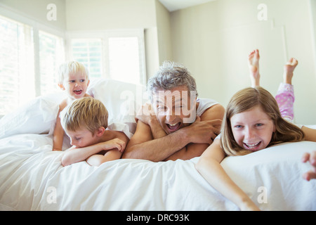 Padre e figli rilassante sul letto Foto Stock