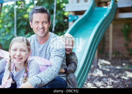 Padre e figli giocare sulla struttura di gioco Foto Stock