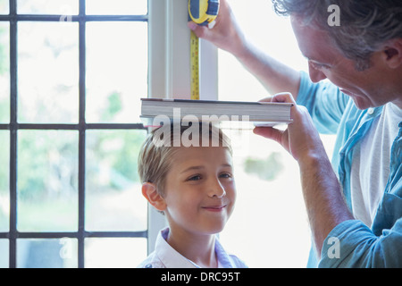 Padre figlio di misurazione dell'altezza sulla parete Foto Stock