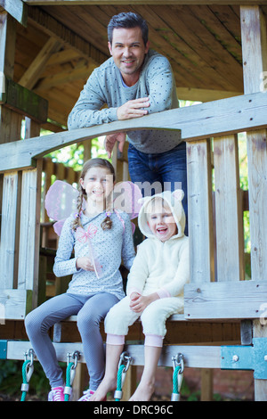 Il padre e i bambini che giocano su playset Foto Stock