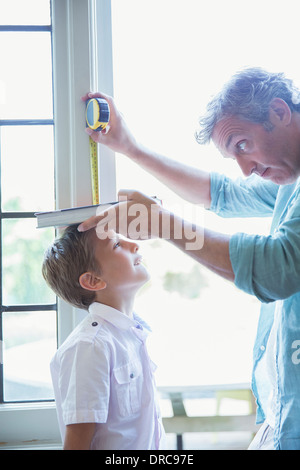 Padre figlio di misurazione dell'altezza sulla parete Foto Stock