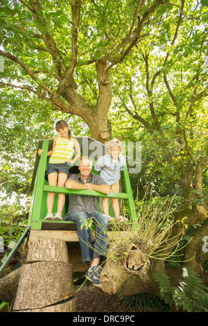 Padre e figli giocare in treehouse Foto Stock
