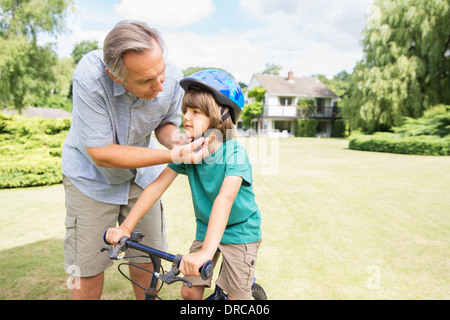 Regolazione del nonno noleggio casco su nipote Foto Stock