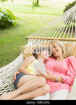 Nonna e nipote con tavoletta digitale in amaca Foto Stock