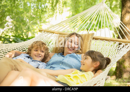 Madre e bambini rilassante insieme in amaca Foto Stock