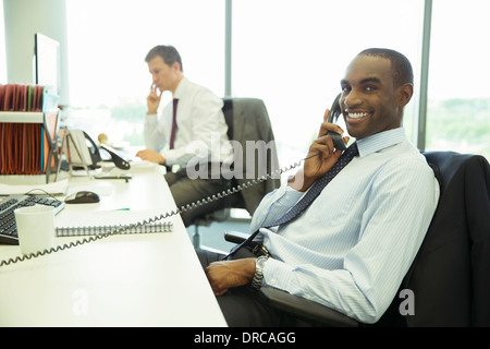 Imprenditore parlando al telefono in ufficio Foto Stock
