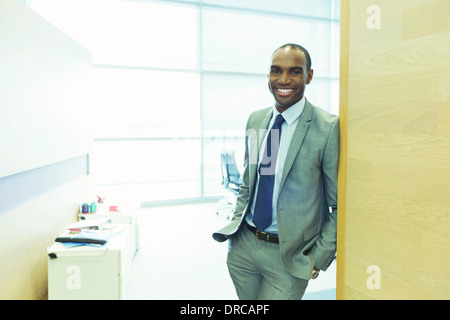 Imprenditore sorridente in ufficio Foto Stock