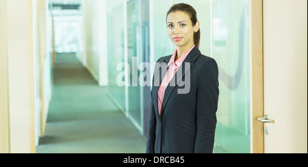 Imprenditrice in piedi in ufficio Foto Stock