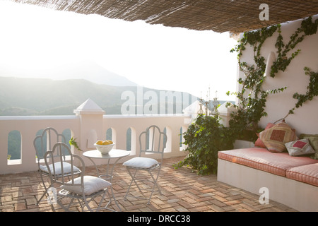 Tavolo e sedie sul balcone che affaccia sulle montagne Foto Stock