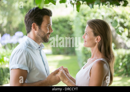 Giovane holding hands faccia a faccia in giardino Foto Stock