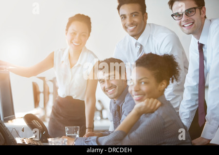 La gente di affari sorridente al computer in ufficio Foto Stock