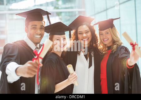 I laureati sorridente con diploma Foto Stock