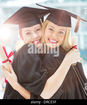 Sorridente abbracciando laureati Foto Stock