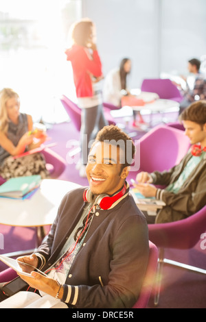 Studente universitario con tavoletta digitale nella lounge Foto Stock