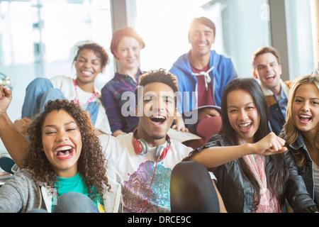 Gli amici il tifo assieme al chiuso Foto Stock