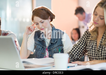 Gli studenti universitari la lettura in classe Foto Stock