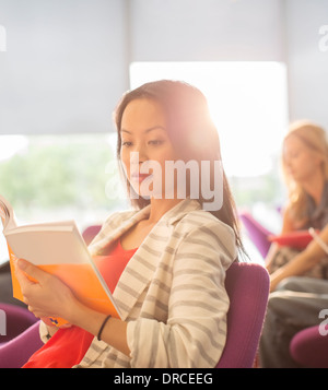 Studente universitario lettura nella lounge Foto Stock