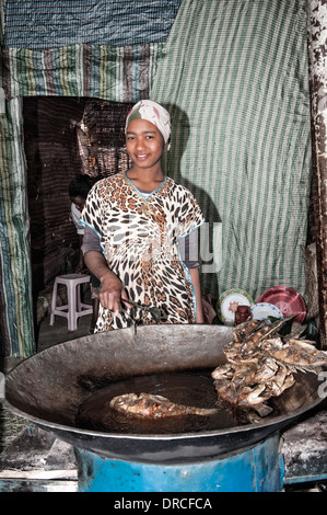 Giovane donna cucinare il pesce, Awasa Harbour, Etiopia Foto Stock