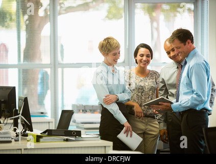 La gente di affari con tavoletta digitale parlando in ufficio Foto Stock