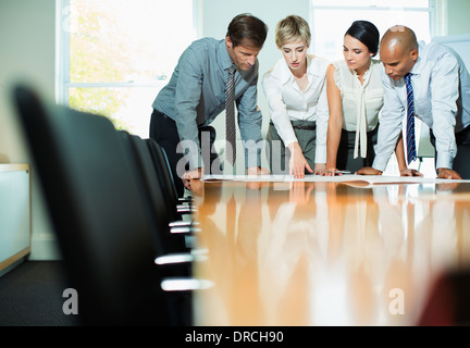 La gente di affari esaminando blueprint in riunione Foto Stock