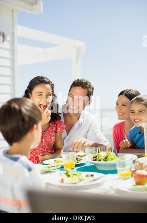 Famiglia di mangiare il pranzo sul patio soleggiato Foto Stock