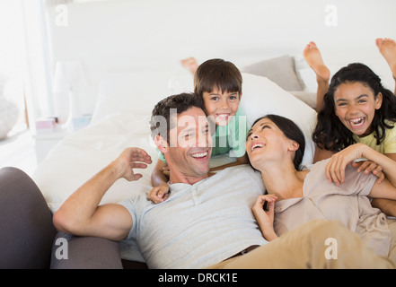 Famiglia di ridere e rilassarsi sul divano Foto Stock